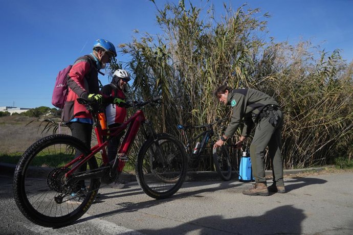 Un agent rural des Mossos d'Esquadra désinfecte les vélos de certains cyclistes dans les zones restreintes par la quarantaine contre la peste porcine africaine